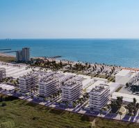 The coast with new apartment buildings and palm trees in the town of El Puig, overlooking the sea.
