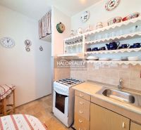 A kitchen in a 2-room apartment with a wooden decor and open shelves.
