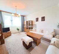 Living room in a two-room apartment with light furniture and a carpet.