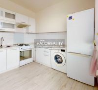 A kitchen in a 2-room apartment with white cabinets, appliances, and a floor with a wood decor.