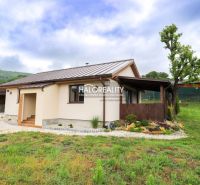 A family house in Dohňany with a lawn and a gazebo in the garden, with hills visible behind it.