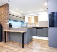 A kitchen in a family house with tiles, a gray kitchen unit, and a floor with a wooden decor.