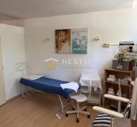 A cosmetic room with a bed, chairs, and decorations, floor with wooden decor.