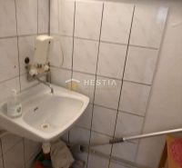 Sink, white tiles, and wall pipes in commercial premises.
