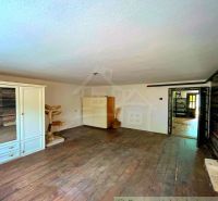 Interior of a family house with a wooden decor floor, a cabinet, and a table.