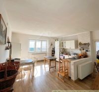 A kitchen in a family house with a wooden decor floor and white furniture.