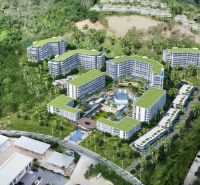 An aerial view of apartment construction in Phuket, surrounded by greenery and palm trees.