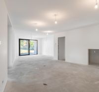 A spacious living room in a family house with large French windows and white walls.