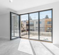 Glass doors leading to the terrace in a family house, white wall, and sunlight.