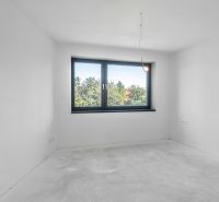 A minimalist room with a large window in a family house, white walls, and a concrete floor.