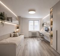 A bright room with a bed, a desk, and a wooden decor floor in a three-room apartment.