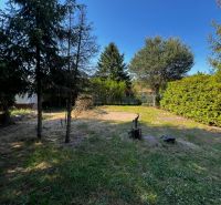 Garden with lawn and trees near the cottage in Lozorno Gardens in Lozorno.