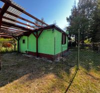 A cottage with a pergola on Lozorno Záhrady Street in Lozorno, surrounded by greenery and a fence.