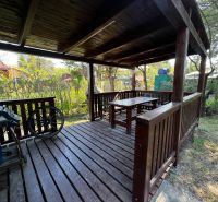 Wooden terrace at a cottage in Lozorno on Lozorno Záhrady street, surrounded by trees and shrubs.