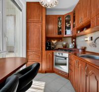 Compact kitchen in a 2-room apartment with wooden decor and kitchen appliances.