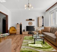 Living room in a two-room apartment with a wooden decor floor and comfortable furniture.
