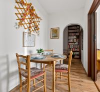 Dining area in a 2-room apartment with a wooden decor floor and wall decoration.