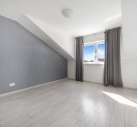 A bright room with a wooden decor floor and a sloped ceiling in a family house.