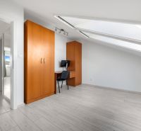 A bright room in a family house with two wardrobes and a table, wooden floor decor.