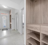 Entrance hallway in a family house with tiled flooring and wooden decor furniture.