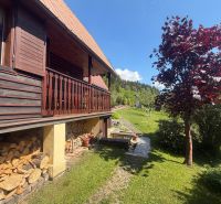A cottage on Bukovská Road in Čadca with wooden cladding and a garden with a red tree.