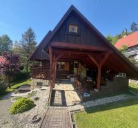 A wooden cottage on Bukovská Road in Čadca, surrounded by greenery and a garden.