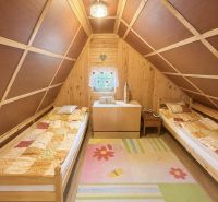 The interior of a cabin with two beds and a floor with wooden decor and a colorful carpet.