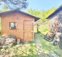 A cottage on Bukovská Road in Čadca with a wooden shed and a pile of wood.