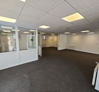 Offices with white walls and a glass partition, floor with carpet decor.