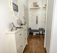 A hallway in a 2-room apartment with a decorative mirror and shoe furniture.