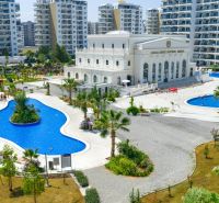 Exterior in Iskele with pools, landscaped gardens, and surrounding apartment complexes.
