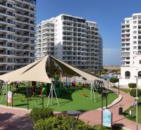 A playground surrounded by high-rise buildings in Iskele, near a studio apartment, on a sunny day.