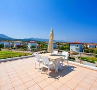 Terrace of a 2-bedroom apartment in Tatlisu with mountain and sea views.