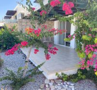 The floral exterior of a 2-bedroom apartment in Tatlisu with a terrace and a garden path.