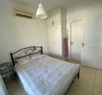Bedroom in a 2-room apartment with a metal bed, white wardrobe, and air conditioning.