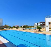 In the outdoor environment of Tatlisu, there are pools and modern buildings of a 2-bedroom apartment.