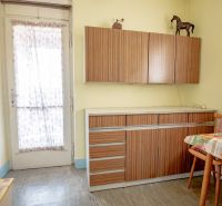 Kitchen of a 2-room apartment with retro cabinets and a dining table.