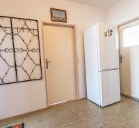 Entrance hallway with a cabinet, coat rack, picture, and floor with wooden decor in a 2-room apartment.