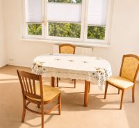 Dining room in a 3-room apartment with three chairs and a large window with a view.