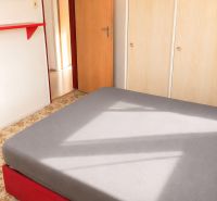 A room with a bed, a wardrobe, and a carpet in a 3-room apartment.