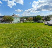 The greenery on residential plots in Horná Ves surrounds the houses and hills.