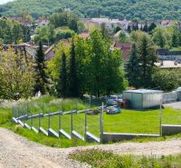 Land - housing in Horná Ves; green areas and village houses on the slope.