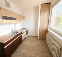 A kitchen in a 2-room apartment with wooden decor and large windows.