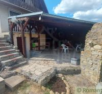 A cottage in Holíč with a covered terrace made of stone materials and plastic chairs.