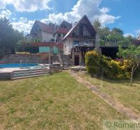 A cottage in Holíč with a pool and a garden surrounded by green vegetation.
