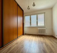 A room in a three-room apartment with a wooden decor floor and a built-in wardrobe.