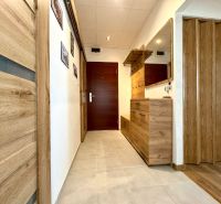 A hallway with a wooden decor floor in a 3-room apartment.