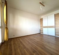 A room in a 3-room apartment with a wooden decor floor and a large wardrobe.
