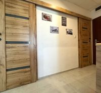 Interior of a 3-room apartment with wooden decor doors and pictures on the wall.