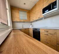 A kitchen in a 3-room apartment with wooden decor and appliances.